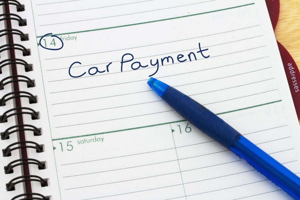 Car payment on 14th day of month circled in calendar book.