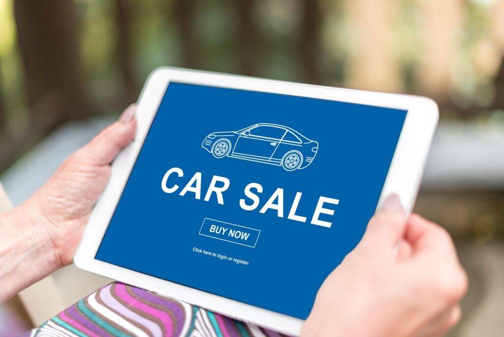 An online car sale platform on a tablet device held by newcomer to Canada