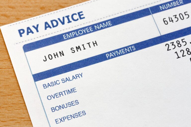 A pay stub in blue print with an employee name, number and salary printed.