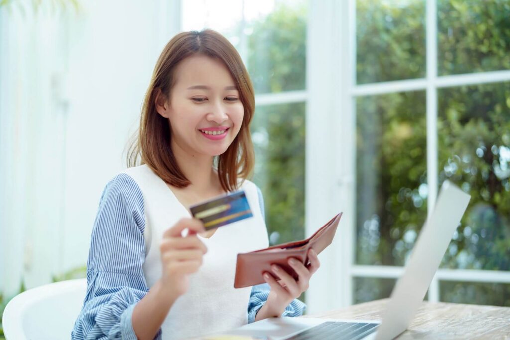 Person paying off credit card in front of laptop