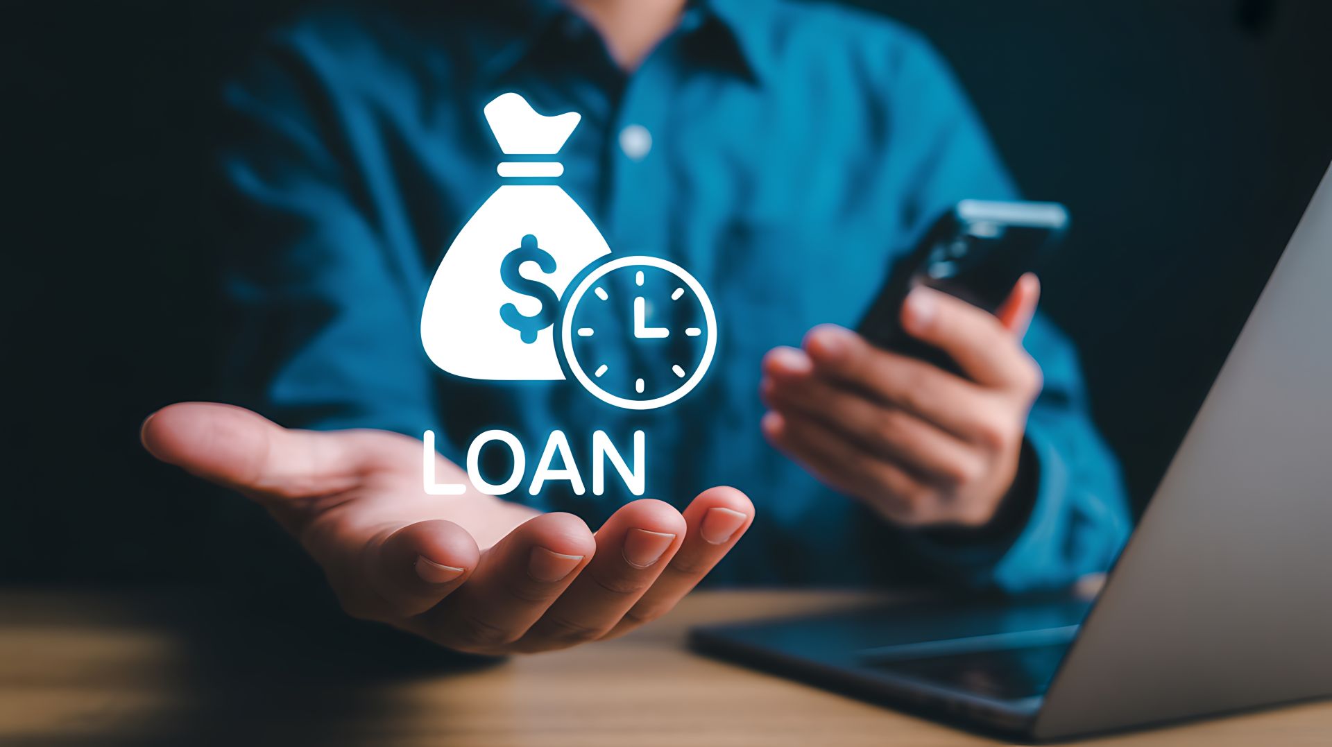 man with smartphone and laptop gets online loan approval popup concept in hand