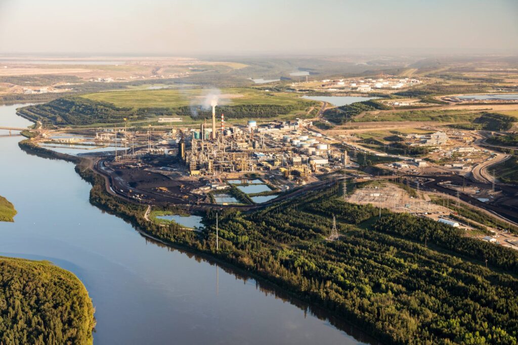 fort mac aerial view of an oil refinery outside of town at sunset in summer